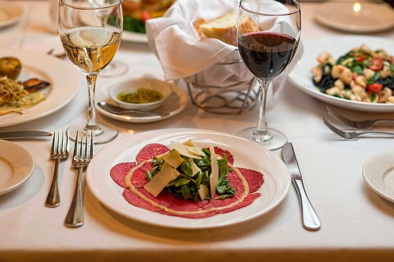 Cured meat topped with cheese and arugula