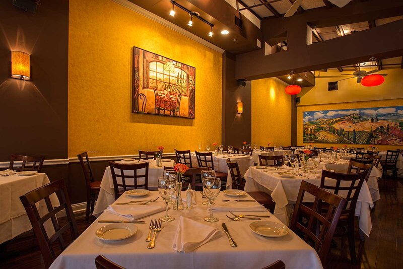 Dining room with yellow walls and many set tables