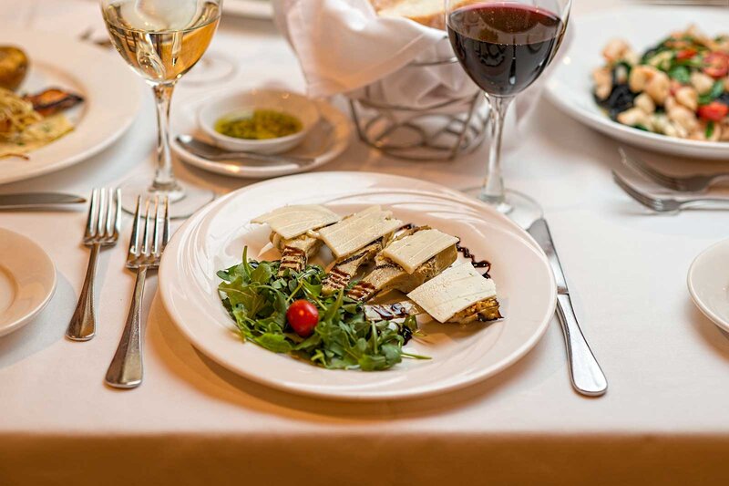 Artichoke hearts topped with cheese and a bed of arugula